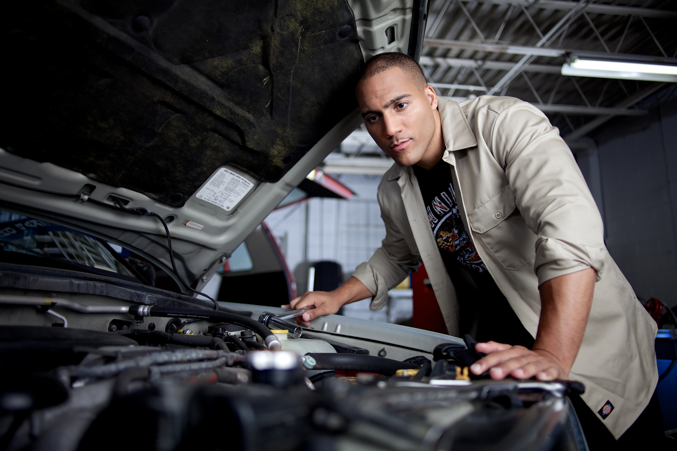 retail fashion photography of a mechanic working on a car by travis neely